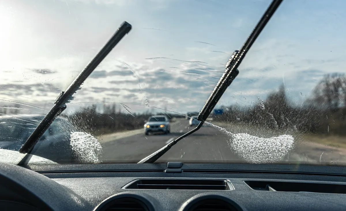 Wiper blades clearing a windscreen on the road