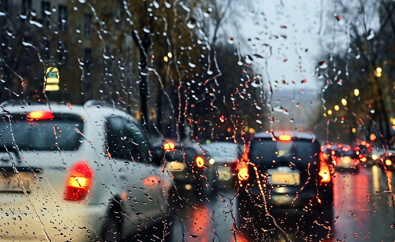 Rainy windshield with old wipers - unclear view at night